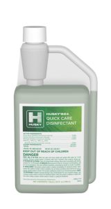 A plastic bottle of 824 - Quick Care Disinfectant featuring a green label, white cap, and an integrated measuring chamber. The label displays active ingredients and safety warnings to provide clear guidance for safe and effective use.