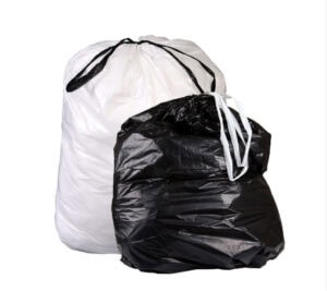 A filled and tied Draw-Tuff® Institutional Liner (40.5″ x 42.5″, 1.0 mil) is placed next to a black garbage bag against a plain white background.